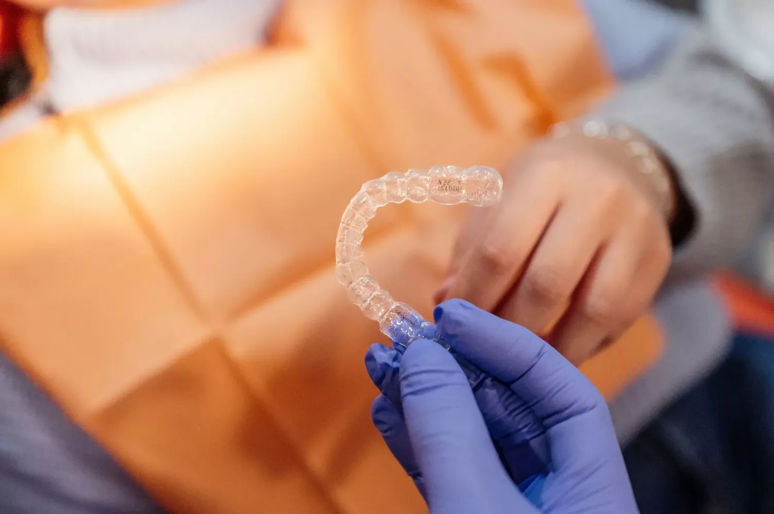 Profesional dentista sujetando una ortodoncia invisible